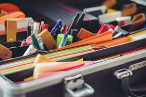 Színes tollak, filcek és jegyzetlapok egy nyitott dobozban